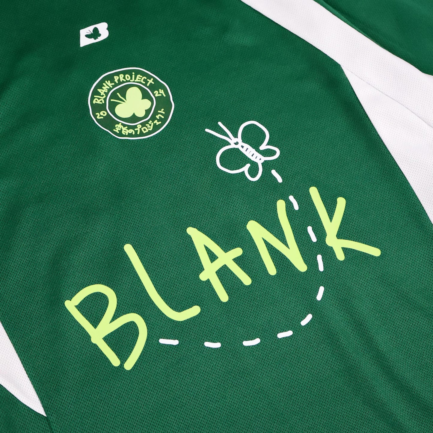 Hand-drawn badge and butterfly graphic on green football shirt
