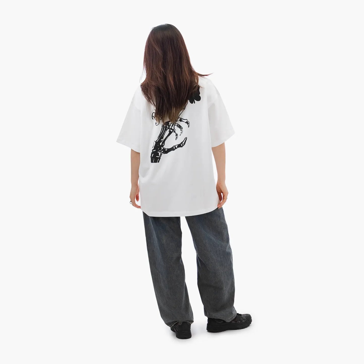Model wears Blank Project Skeleton Hand Graphic Short Sleeve T-Shirt in white color